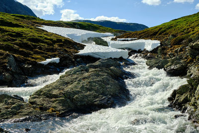 Scenic view of river and mountains against sky