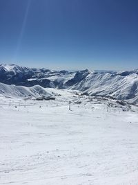 Scenic view of snowcapped mountains against clear blue sky