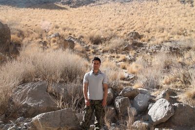 Portrait of young man standing on rock