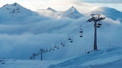 Overhead cable car over snowcapped mountains against sky