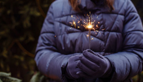 Midsection of women holding sparkler