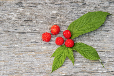 Close-up of raspberries and leaves on wooden table