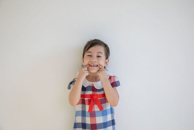 Portrait of girl standing against white background