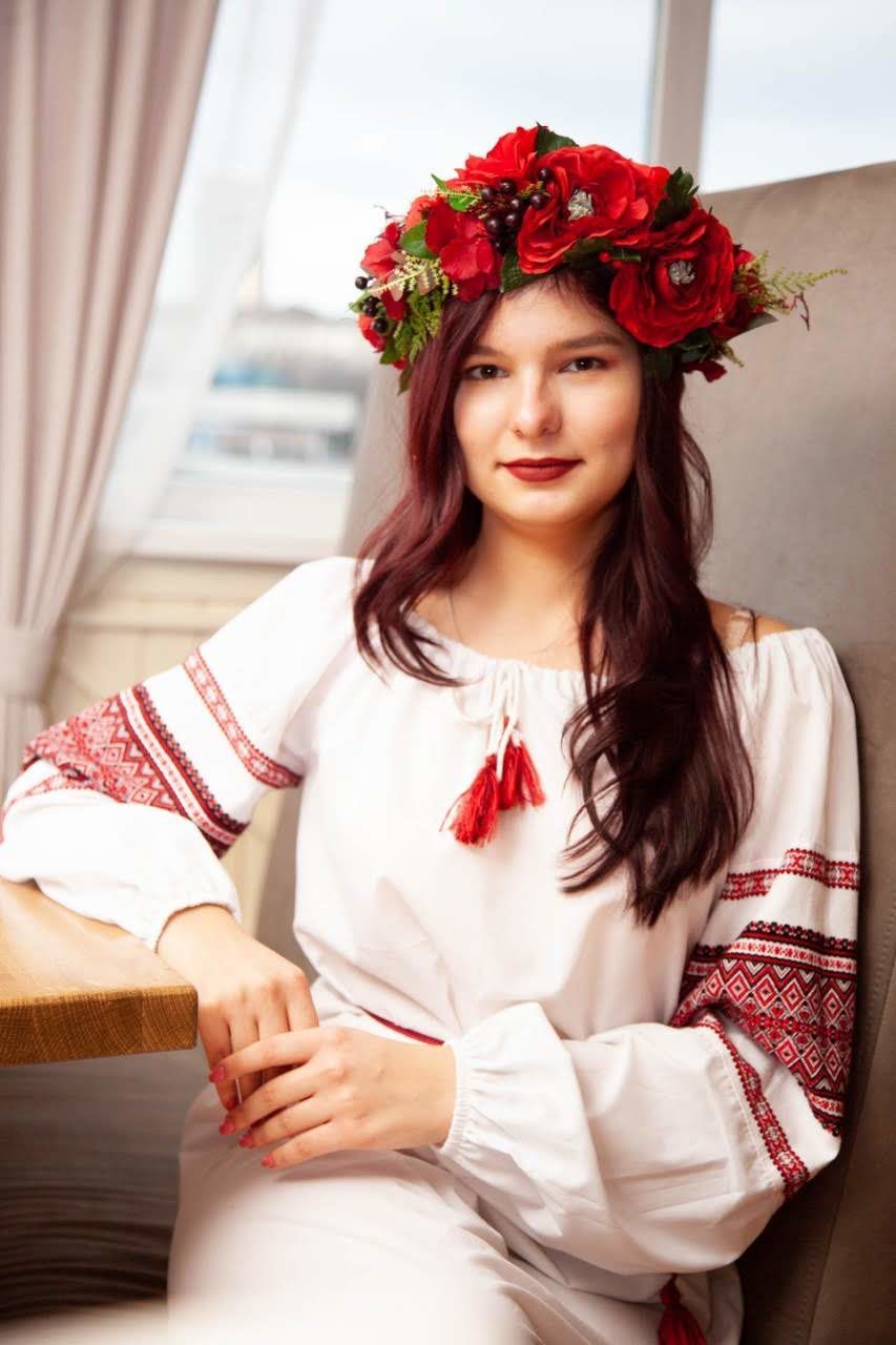 smiling, looking at camera, portrait, one person, flower, happiness, young adult, flowering plant, women, sitting, adult, indoors, emotion, red, beautiful woman, waist up, beauty, front view, plant, hairstyle, flower arrangement, bouquet