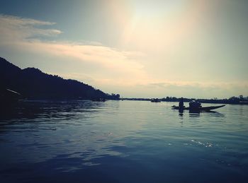 Boats in sea at sunset