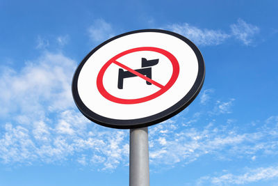 Low angle view of road sign against blue sky