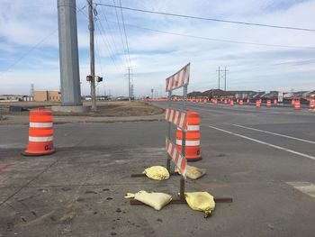 Traffic cones on road against sky