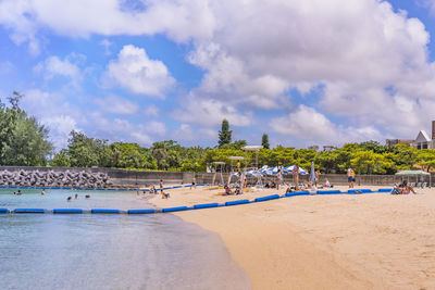 Vacationers in swimsuit tanning and having fun on the beach naminoue  in okinawa prefecture, japan.