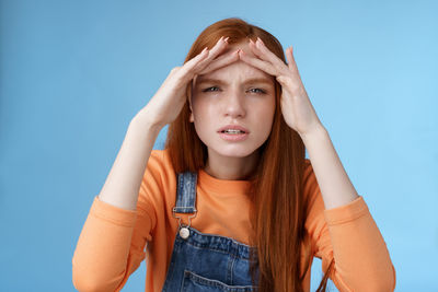 Portrait of beautiful young woman against blue background