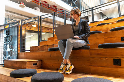 Low angle view of young man sitting on staircase