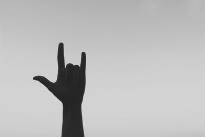 Close-up of silhouette hand against clear sky