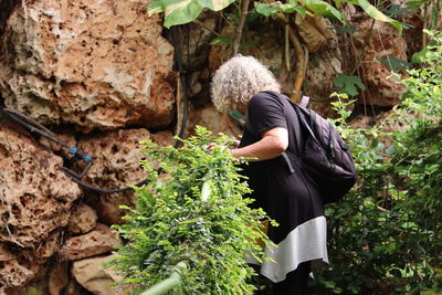 Rear view of woman standing amidst plants