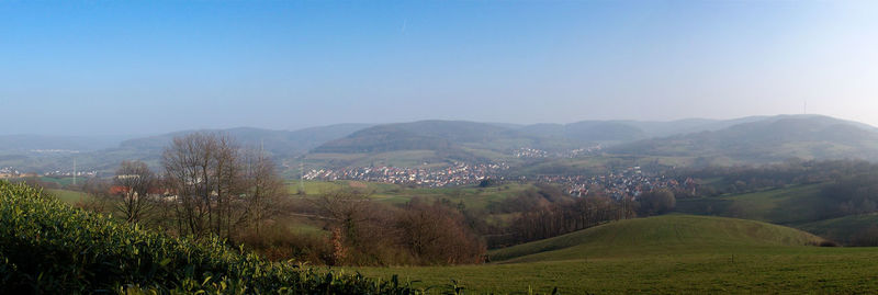 View of rural landscape with mountain range in background