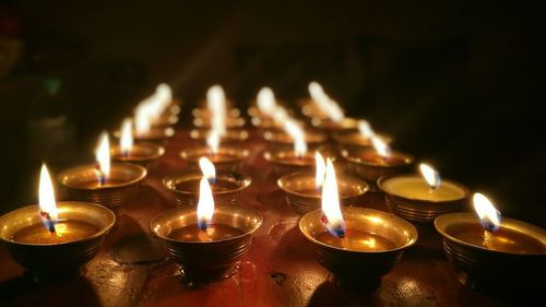 Close-up of illuminated candles in temple