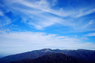 Scenic view of mountains against blue sky