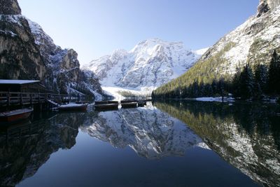 Scenic view of lake by snowcapped mountains against clear sky