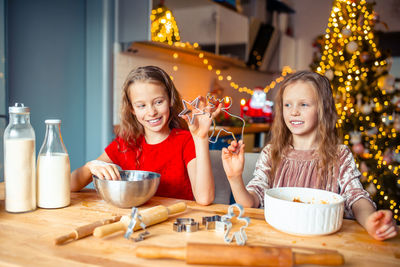 Portrait of smiling girl holding food on table