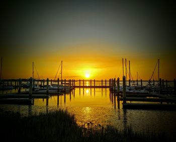 Silhouette boats in sea against sky during sunset