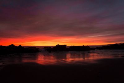 Scenic view of sea against dramatic sky during sunset