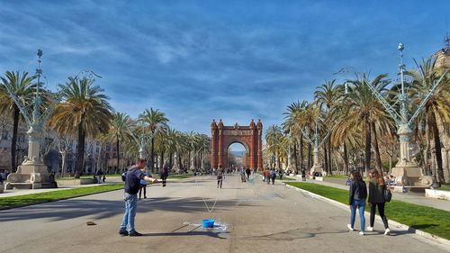 People walking in front of palm trees