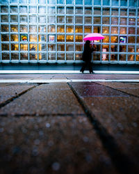 Full length of woman walking against building in city