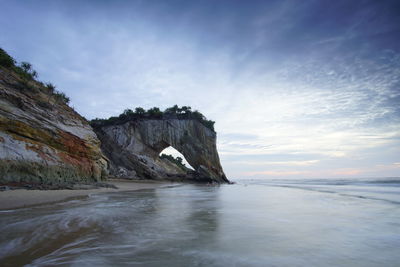 Rock formations in sea against sky