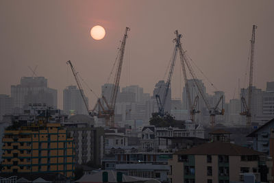 Buildings in city against sky during sunset