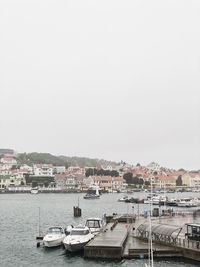 Boats in harbor against buildings in city