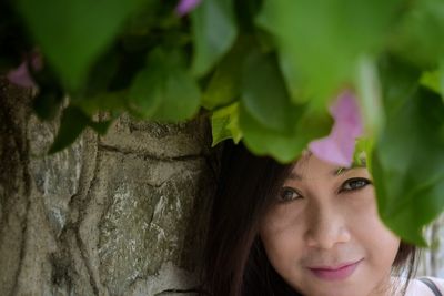 Close-up portrait of smiling young woman against blurred background