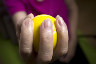 Close-up of woman holding yellow ball