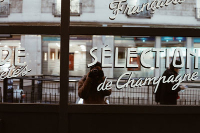 Reflection of people on glass window at store