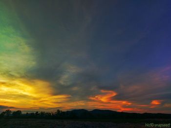 Scenic view of dramatic sky over landscape during sunset