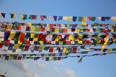 Low angle view of flags against blue sky