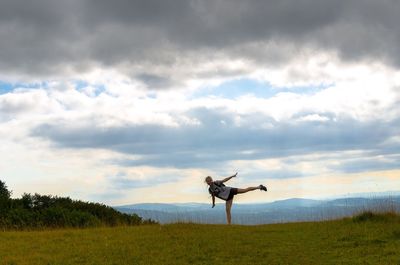 Portrait of woman standing with arms outstretched against sky