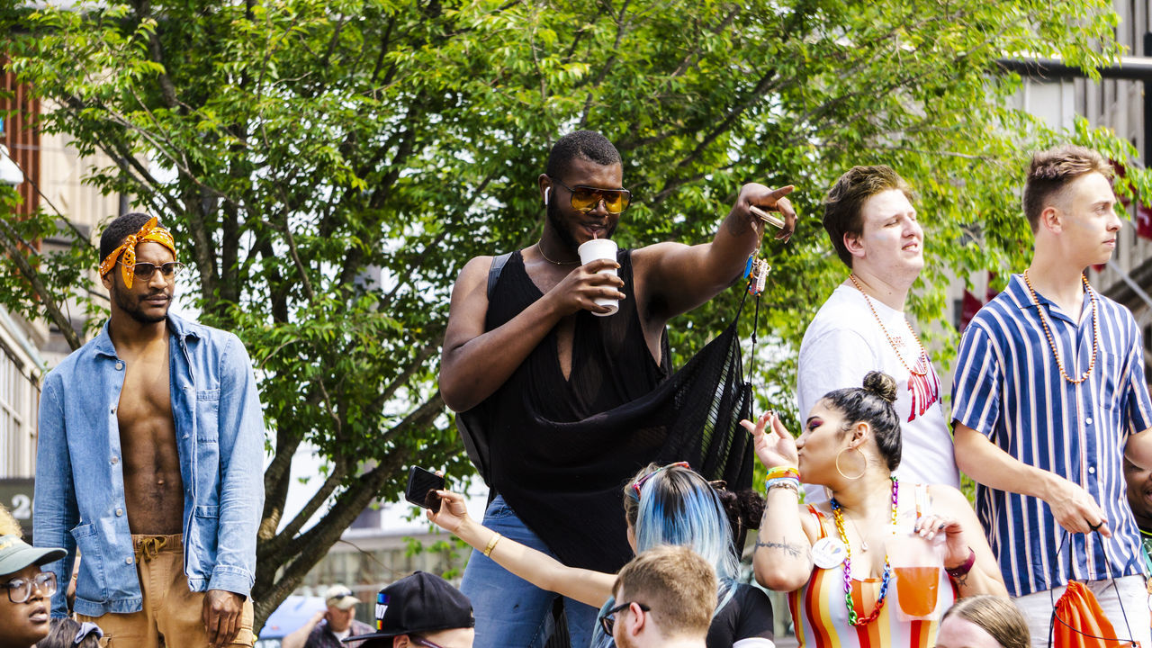 group of people, men, day, young men, tree, friendship, crowd, plant, real people, young adult, celebration, togetherness, standing, people, lifestyles, arts culture and entertainment, adult, leisure activity, glasses, casual clothing, outdoors