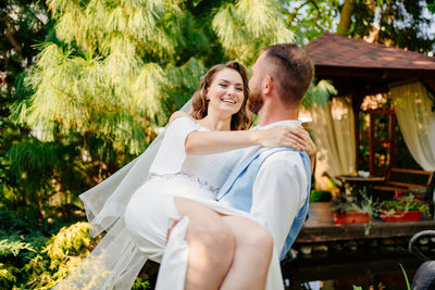 Groom picking up bride outdoors