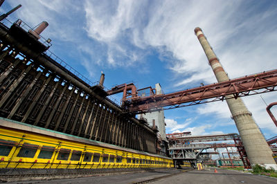 Low angle view of smoke stack against sky at factory