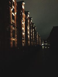 Illuminated buildings by river at night