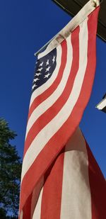 Low angle view of flag against clear blue sky