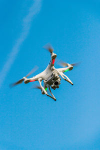 Low angle view of airplane flying against clear blue sky