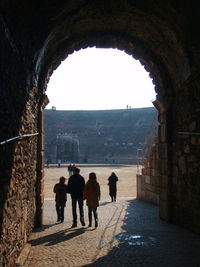 People walking at the entrance to an ancient roman arena