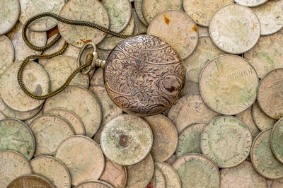 Back cover pocket watch on a bunch of old silver coins