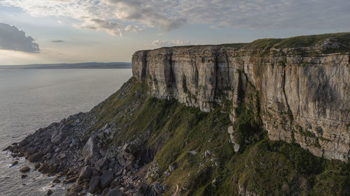 Panoramic view of rocks on sea shore against sky