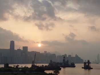 Scenic view of sea and buildings against sky during sunset