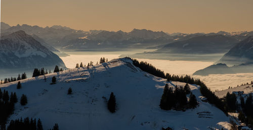 Scenic view of snowcapped mountains against sky during sunset