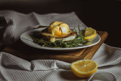 Eggs benedict and poached hollandaise sauce with arugula and lemon. delicious food for breakfast. 