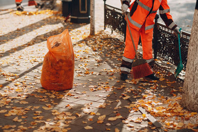 Low section of person working on footpath during autumn