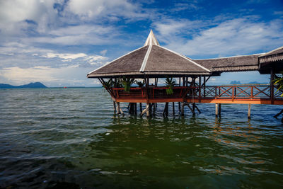 Pier over sea against cloudy sky