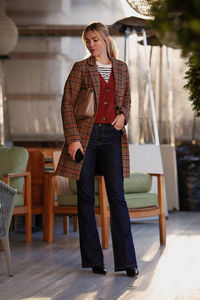 Autumn or spring street style trend. beautiful fashion model wearing brown plaid coat, denim pants