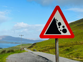 Close-up of road sign against sky